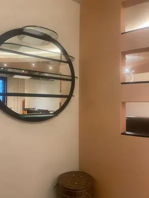 a mirror hanging on a wall with a trash can at South Park Cozy Flat in Sofia