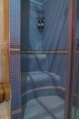 a shower with a chair and a shower curtain at South Park Cozy Flat in Sofia