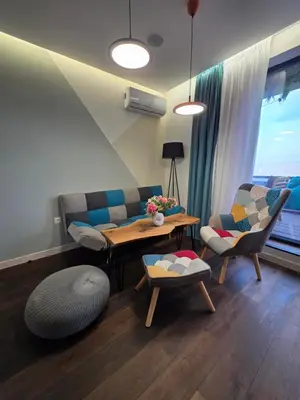 a living room with a couch and a table and chairs at ApArt by the river in Plovdiv