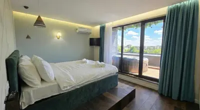 a bedroom with a bed and a large window at ApArt by the river in Plovdiv