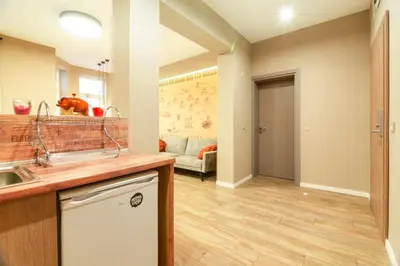 a kitchen with a sink and a living room at 1 BR Wine Journey in Sofia