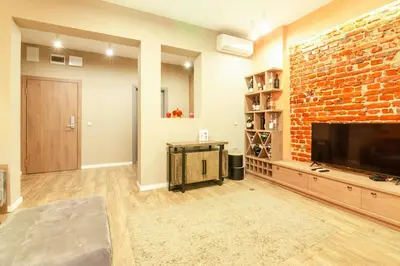 a living room with a brick wall and a flat screen tv at 1 BR Wine Journey in Sofia