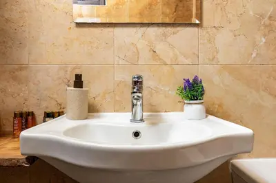 a white sink in a bathroom with flowers on it at Vacation Home in Starosel Resort in Starosel