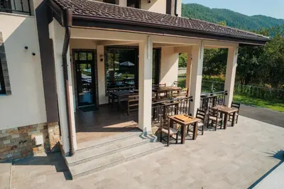 a pavilion with tables and chairs on a patio at Къща за гости Бели Осъм in Beli Osŭm