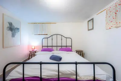 a bedroom with a bed with purple pillows at Social Apartment in Sofia