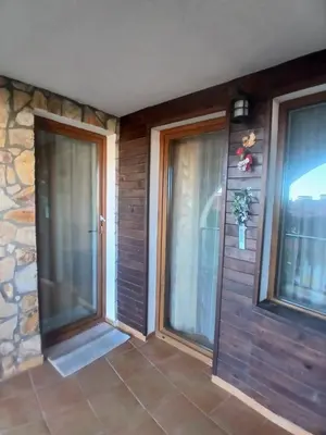 two glass doors in a room with a stone wall at Grand Monastery apt Emo Pamporovo in Smolyan