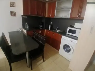 a kitchen with a table and a washing machine at Grand Monastery apt Emo Pamporovo in Smolyan