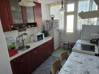 a kitchen with a table and a sink and a refrigerator at Affordable 3BR near Centre in Sofia