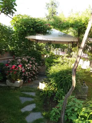 a garden with a pergola and a path at Stai Za Gosti Venera in Hisarya