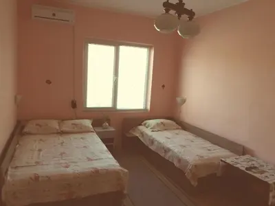 two beds in a room with a window at Stai Za Gosti Venera in Hisarya