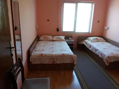 two beds in a small room with a window at Stai Za Gosti Venera in Hisarya