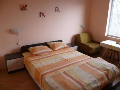 a bedroom with a bed and a chair in it at Stai Za Gosti Venera in Hisarya
