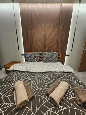 a bedroom with a large bed with a wooden headboard at Luxury Forest Apartment in Borovets