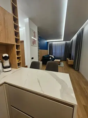 a kitchen with a counter top and a living room at Luxury Forest Apartment in Borovets