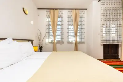 a bedroom with a large white bed and two windows at Vacation Apartment in Starosel complex in Starosel