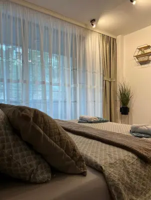 two beds in a bedroom with a large window at ViVa SPA Retreat in Velingrad