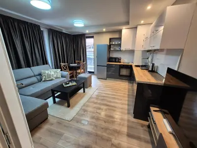 a living room with a blue couch and a kitchen at SUPERsonicondo 4 in Plovdiv