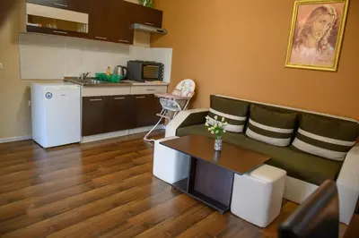 a living room with a couch and a kitchen at Вилен комплекс Дарибел in Sapareva Banya