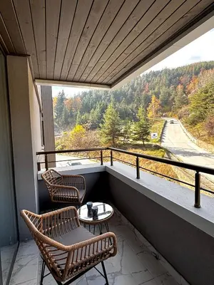 a balcony with two chairs and a table with a view at Thermal Bliss Apartment in Velingrad