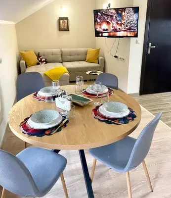 a dining room table with chairs and a couch at 1BR Apartment Near Gondola by SI Stay in Bansko