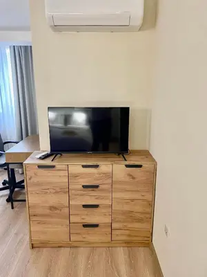 a flat screen tv sitting on top of a wooden dresser at 1BR Apartment Near Gondola by SI Stay in Bansko