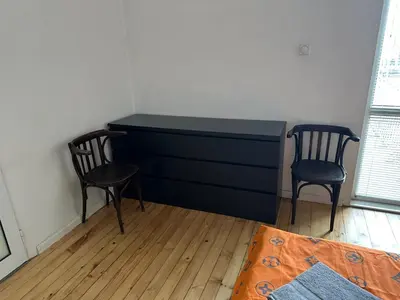a black dresser with two chairs in a room at Апартамент 21 in Sofia