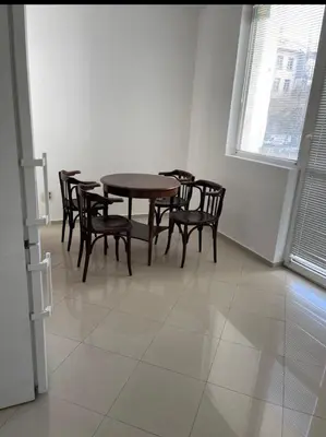 a dining room with a wooden table and chairs at Апартамент 21 in Sofia