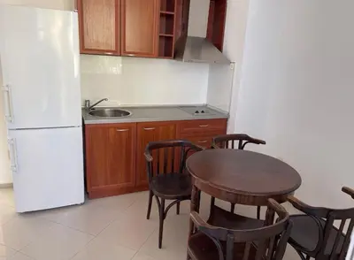 a kitchen with a table and a white refrigerator at Апартамент 21 in Sofia