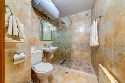 a bathroom with a toilet and a sink at Alpine Hideaway at The Castle in Smolyan