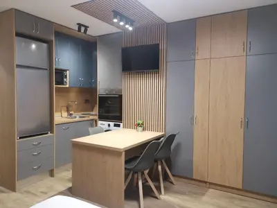 a kitchen with blue cabinets and a wooden table and chairs at West Park in Sofia