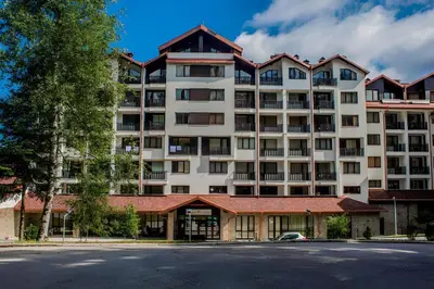 a large white apartment building with a red roof at RIA studio in Borovets Gardens hotel in Borovets