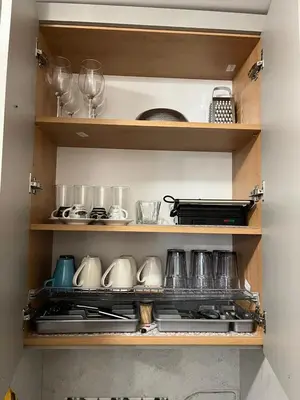 a kitchen shelf with pots and pans and wine glasses at RIA studio in Borovets Gardens hotel in Borovets