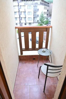 a balcony with a table and a chair and a window at Apartment Dream - Comfort & Calm in Pirin Sense by Flat Mаnаger in Bansko