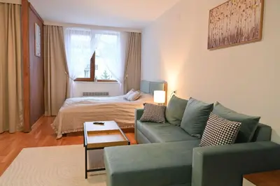 a living room with a couch and a bed at Apartment Dream - Comfort & Calm in Pirin Sense by Flat Mаnаger in Bansko