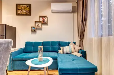 a living room with a blue couch and a table at Ski-Friendly Family Getaway in Pamporovo