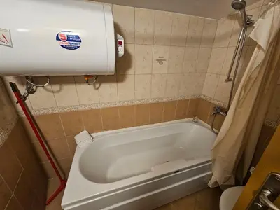 a bath tub in a bathroom with a toilet at Rooftop apartment with stunning view in Beli Iskar
