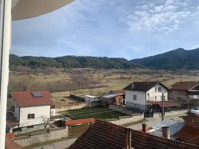 a view of a village with houses and mountains at Rooftop apartment with stunning view in Beli Iskar