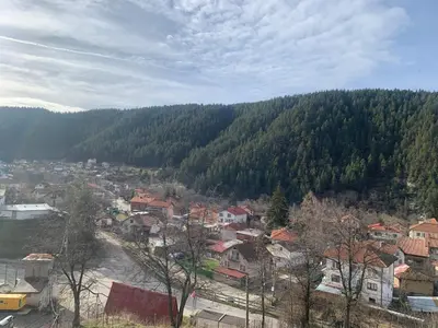 a view of a town in a valley with trees at Rooftop apartment with stunning view in Beli Iskar