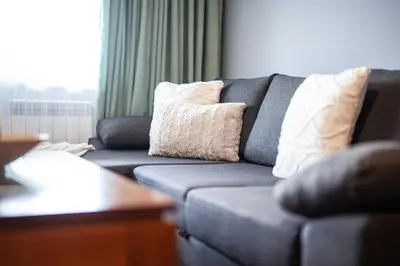 a blue couch with pillows in a living room at 400m from Ski Belvedere Apartment - Free Parking - SPA in Bansko