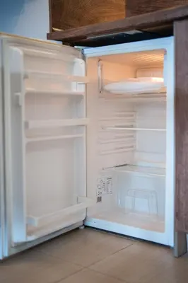 an empty refrigerator with its door open in a kitchen at 400m from Ski Belvedere Apartment - Free Parking - SPA in Bansko