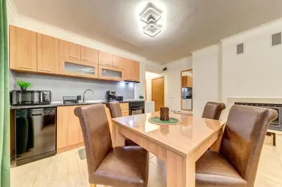 a kitchen with a wooden table and chairs at Winter Heaven Grand Monastery Pamporovo in Pamporovo
