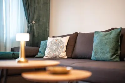 a living room with a couch with pillows and a table at 400m from Ski lift Belvedere Apartment - SPA - Free parking in Bansko