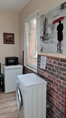 a washing machine in a room with a picture of a person with an umbrella at Guest House The House in Plovdiv