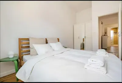 a bedroom with a large white bed with towels on it at Cozy 2BDR Balcony Apt with View in Historic Center in Sofia