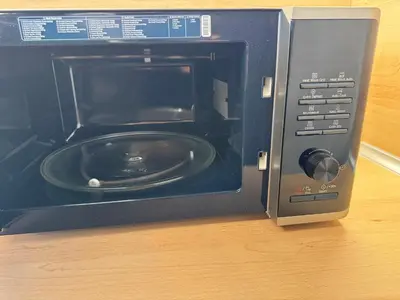 a black microwave oven with a plate in it at Plovdiv Moon - 1 Bedroom Luxury Apartment in Plovdiv