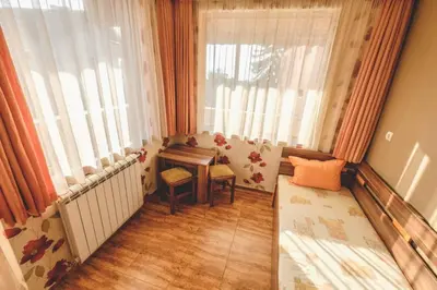 a small room with a table and a window at Къща за гости Бумеранг in Velingrad