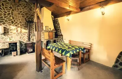 a room with a bench and a fireplace in a building at Къща за гости Бумеранг in Velingrad