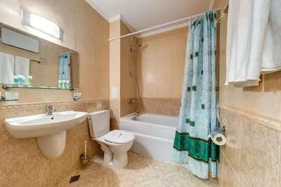a bathroom with a sink and a toilet and a bath tub at Alpine Comfort at Grand Monastery in Pamporovo