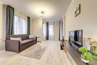 a living room with a couch and a flat screen tv at Warm Mountain Hideout in Pamporovo