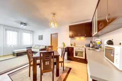 a kitchen and living room with a table and chairs at Slopeview Stay at Grand Monastery in Pamporovo